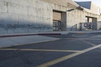 a skateboard parked in a parking lot at an arena with concrete walls and stairs