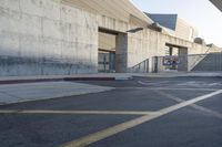 a skateboard parked in a parking lot at an arena with concrete walls and stairs