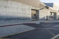 a skateboard parked in a parking lot at an arena with concrete walls and stairs