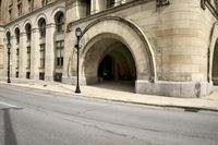 an old arched building is shown with a car parked under the entrance at the end of it