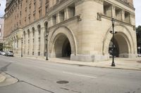 an old arched building is shown with a car parked under the entrance at the end of it