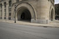 an old arched building is shown with a car parked under the entrance at the end of it