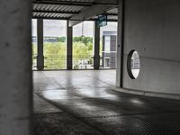 a parking garage with lots of windows on the walls and a view out to the street