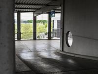 a parking garage with lots of windows on the walls and a view out to the street