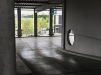 a parking garage with lots of windows on the walls and a view out to the street