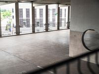 a parking garage with lots of windows on the walls and a view out to the street