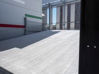 an empty garage with the sun shines on it's back doors and flooring