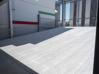 an empty garage with the sun shines on it's back doors and flooring