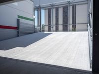 an empty garage with the sun shines on it's back doors and flooring