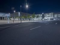 a building with a parking area next to a street sign and lights on it in front of a street