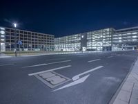 a building with a parking area next to a street sign and lights on it in front of a street