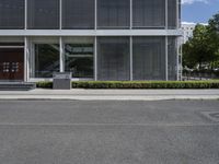 a paved street and a building with grey shutters and steps on either side of it