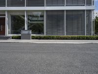 a paved street and a building with grey shutters and steps on either side of it