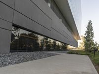 the building is very long and large outside of it's windows the reflection in the glass reflects the landscape