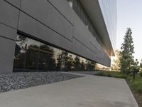 the building is very long and large outside of it's windows the reflection in the glass reflects the landscape