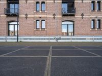 the bicycle is parked in front of a brick building with lots of windows and doors