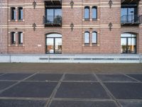 the bicycle is parked in front of a brick building with lots of windows and doors