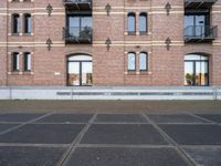 the bicycle is parked in front of a brick building with lots of windows and doors