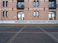 the bicycle is parked in front of a brick building with lots of windows and doors