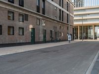 a paved side walk with three bikes parked at the curb and a building in the background