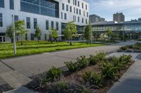 a walkway between two tall buildings with plants growing on the sides of them in front of some grass