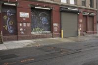 an old building is covered in graffiti and graffiti paper on the side of it, with a fire hydrant, street signs, trash cans and a fire hydrant, some windows and a curb, and a black trash can all