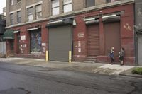 an old building is covered in graffiti and graffiti paper on the side of it, with a fire hydrant, street signs, trash cans and a fire hydrant, some windows and a curb, and a black trash can all