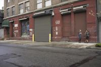 an old building is covered in graffiti and graffiti paper on the side of it, with a fire hydrant, street signs, trash cans and a fire hydrant, some windows and a curb, and a black trash can all