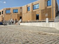 a building that has some steps by it with wooden walls and a bench in front