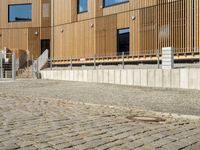 a building that has some steps by it with wooden walls and a bench in front