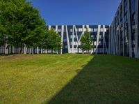 the grass is neatly tended for use by the modern buildings near the park area on the campus