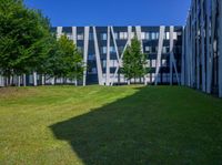 the grass is neatly tended for use by the modern buildings near the park area on the campus