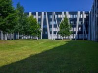 the grass is neatly tended for use by the modern buildings near the park area on the campus