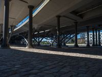 a view of a city from underneath an elevated walkway with benches near it, which has been designed to look like brick