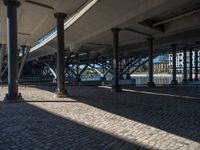 a view of a city from underneath an elevated walkway with benches near it, which has been designed to look like brick