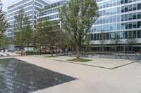 there is a large pool in front of the office buildings in this photo, with reflection