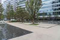 there is a large pool in front of the office buildings in this photo, with reflection