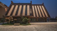 the large wooden house has many balks inside of it and a brick pathway in front