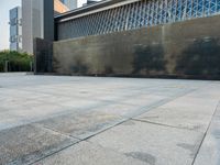 a sidewalk with the letters c painted on it and buildings in the background with a sky line