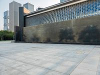 a sidewalk with the letters c painted on it and buildings in the background with a sky line