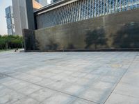 a sidewalk with the letters c painted on it and buildings in the background with a sky line