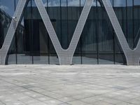 the entrance of a building has many large windows and an outdoor area with people walking