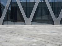 the entrance of a building has many large windows and an outdoor area with people walking