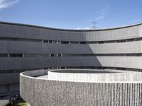 the circular structure is made from concrete bricks, with a lot of grass on the ground below