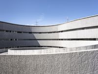 the circular structure is made from concrete bricks, with a lot of grass on the ground below