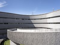 the circular structure is made from concrete bricks, with a lot of grass on the ground below