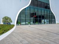 the outside of a building with glass walls and a red fire hydrant sitting next to it