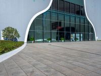 the outside of a building with glass walls and a red fire hydrant sitting next to it