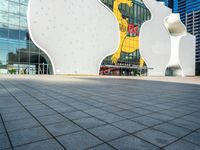 a large white building with three shapes shaped like animals at the base and a large yellow sign in the middle