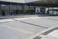 a person sitting at the bench in front of a mall that is empty of people